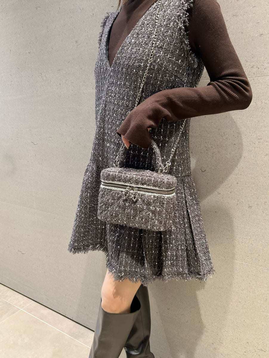 グレー系のワンピース、ブラウン系のニット/セーター、グレー系のハンドバッグを着用したレディースの秋コーディネートの5枚目の写真