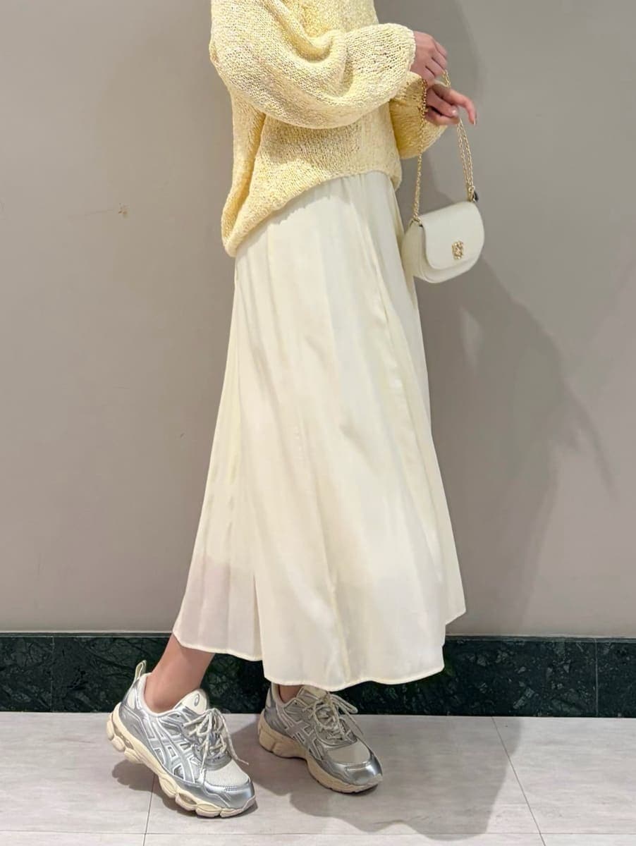 イエロー系のワンピース、ホワイト系のショルダーバッグ、シルバー系のスニーカーを着用したレディースの春コーディネートの5枚目の写真