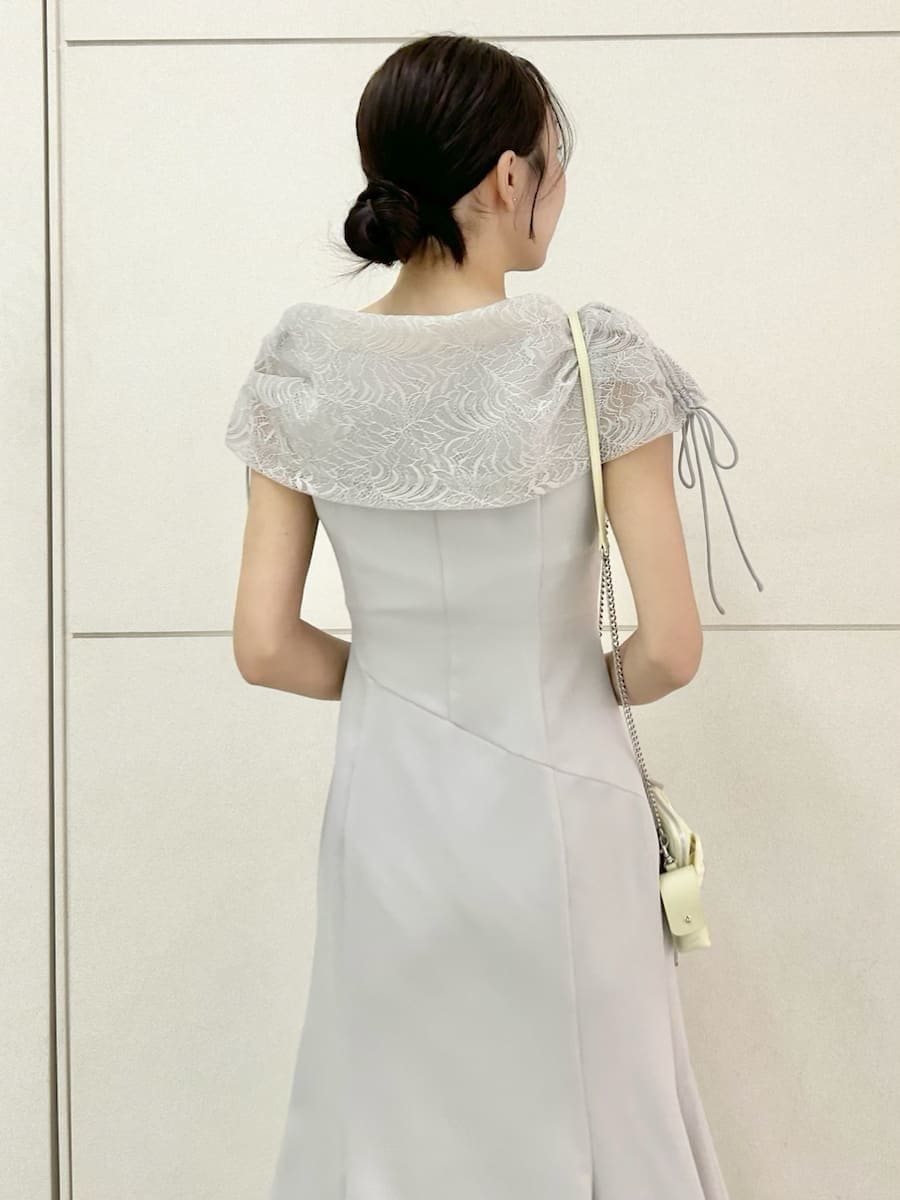 グレー系のドレス、ブラウン系のパンプス、イエロー系のショルダーバッグを着用したレディースの春コーディネートの6枚目の写真