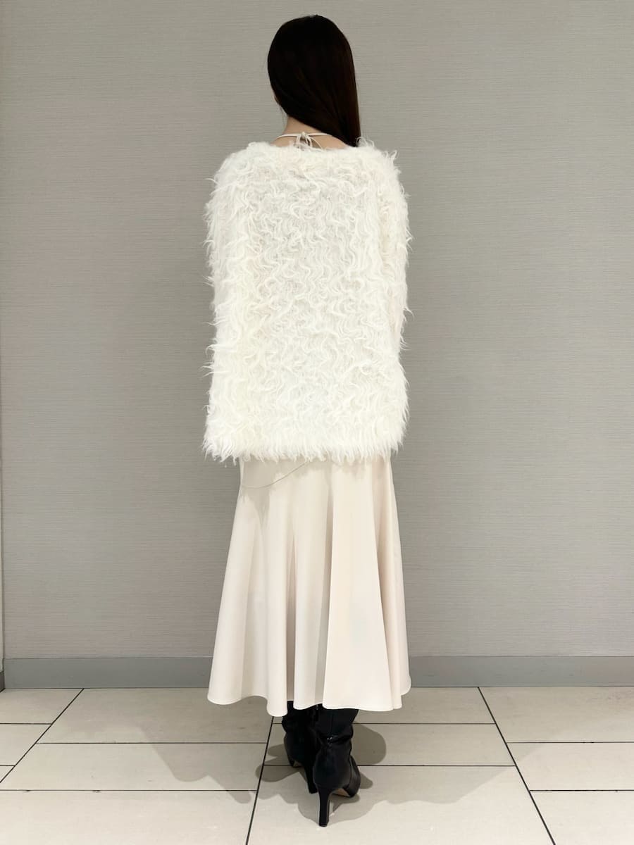 ブラック系のブーツ、ホワイト系のワンピース、ホワイト系のカーディガン/ボレロを着用したレディースの冬コーディネートの3枚目の写真