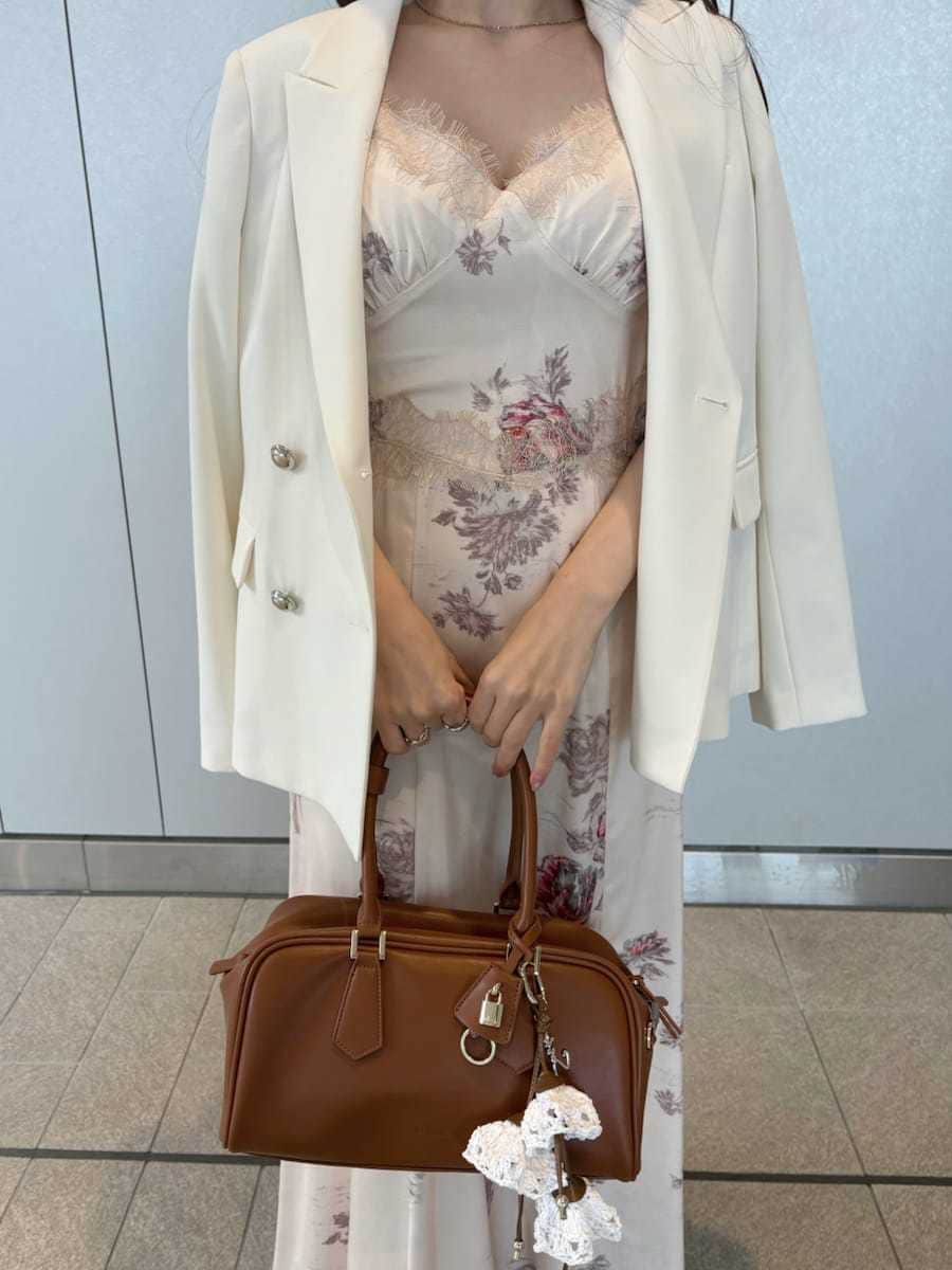 ホワイト系のテーラードジャケット、ホワイト系のワンピース、ブラウン系のパンプスを着用したレディースの春コーディネートの5枚目の写真