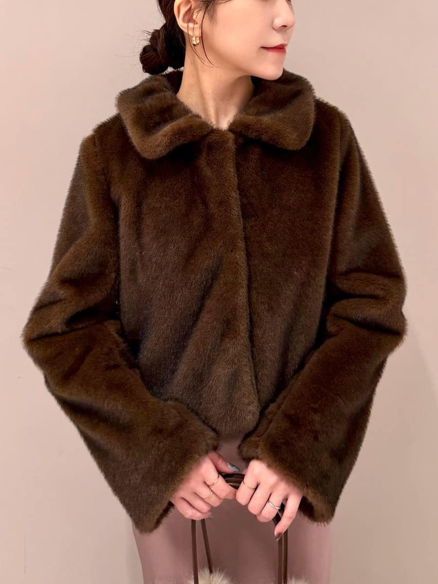 ブラウン系のステンカラーコート、ブラウン系のワンピース、ブラウン系のハンドバッグを着用したレディースの秋コーディネートの4枚目の写真