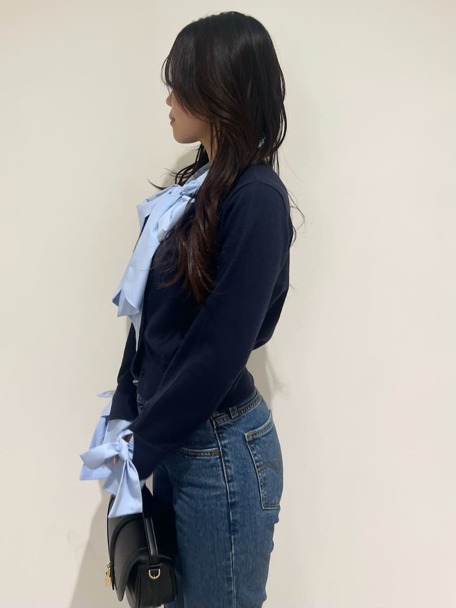 ブルー系のニット/セーター、ブルー系のデニムパンツ、ブラック系のブーツを着用したレディースの秋コーディネートの5枚目の写真