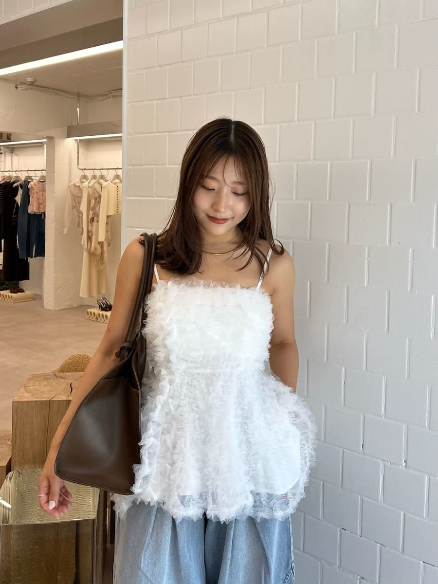 ブラック系のサンダル、ブルー系のデニムパンツ、ブラウン系のトートバッグを着用したレディースの夏コーディネートの9枚目の写真