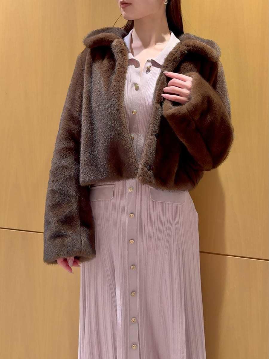 レッド系のブーツ、ブラウン系のステンカラーコート、ピンク系のワンピースを着用したレディースの秋コーディネートの6枚目の写真