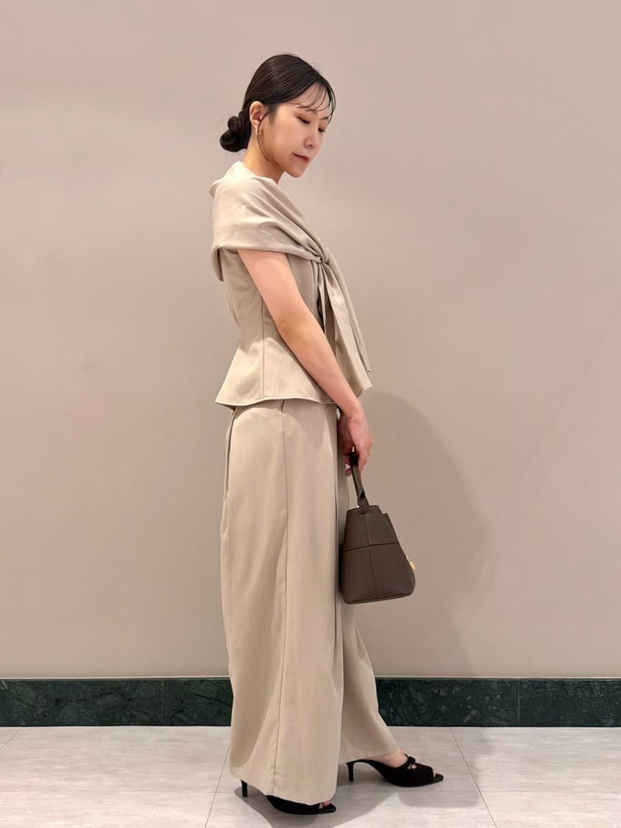 ブラウン系のハンドバッグ、ベージュ系のその他パンツ、ベージュ系のシャツ/ブラウスを着用したレディースの夏コーディネートの3枚目の写真
