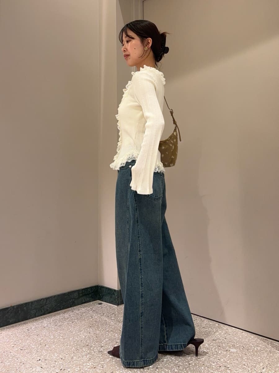 ブルー系のデニムパンツ、ホワイト系のニット/セーター、ブラウン系のサンダルを着用したレディースの夏コーディネートの3枚目の写真
