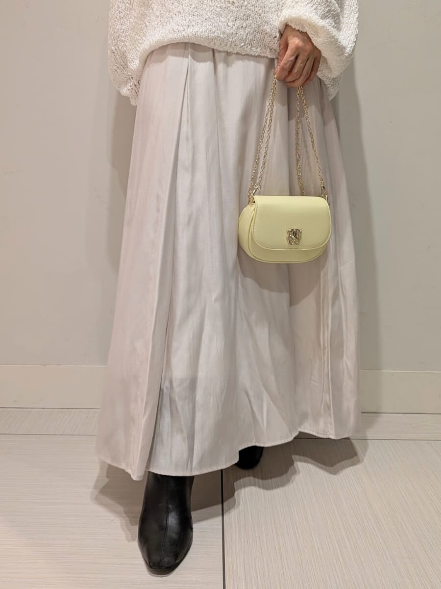 ブラック系のブーツ、ホワイト系のワンピース、イエロー系のショルダーバッグを着用したレディースの冬コーディネートの5枚目の写真