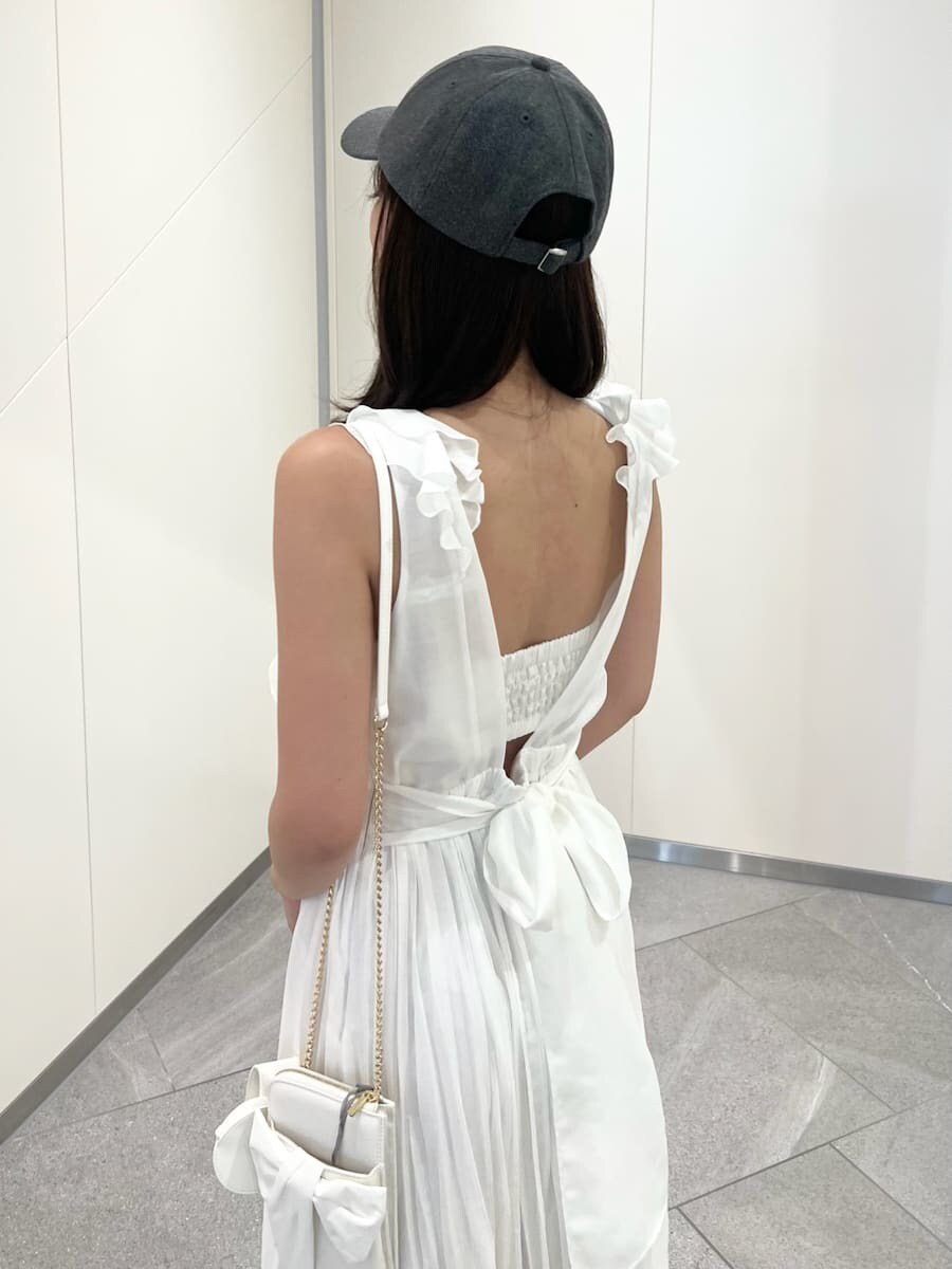 ホワイト系のショルダーバッグ、ホワイト系のワンピース、グレー系のキャップを着用したレディースの夏コーディネートの7枚目の写真