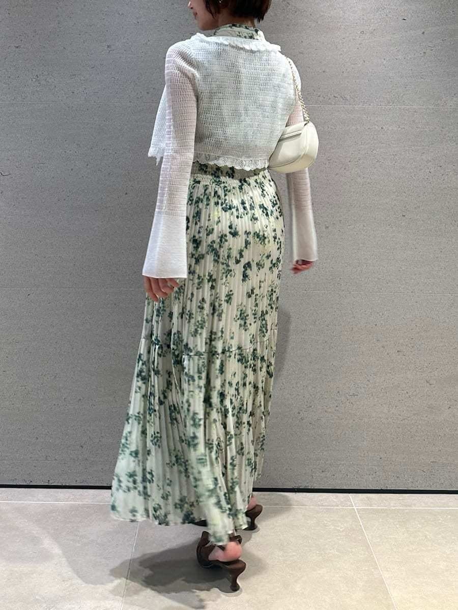 グリーン系のワンピース、ホワイト系のカーディガン/ボレロ、ブラウン系のパンプスを着用したレディースの冬コーディネートの4枚目の写真