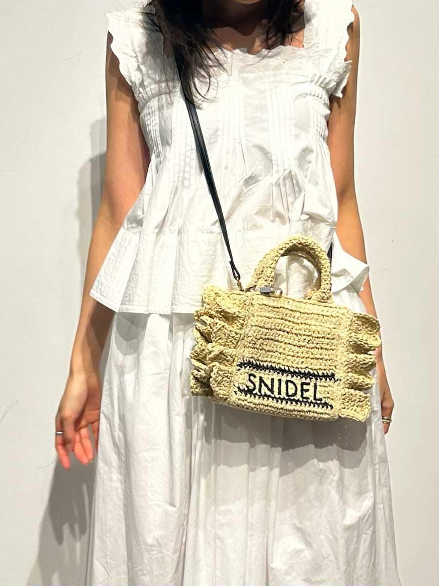 ホワイト系のスカート、ホワイト系のシャツ/ブラウス、ベージュ系のショルダーバッグを着用したレディースの冬コーディネートの6枚目の写真