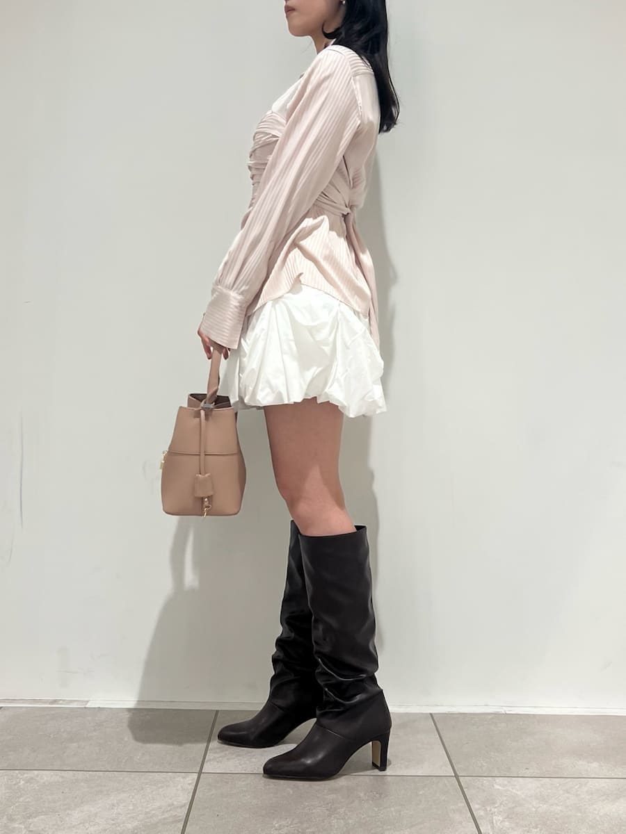 ピンク系のショルダーバッグ、ベージュ系のチェスターコート、ホワイト系のその他パンツを着用したレディースの冬コーディネートの6枚目の写真