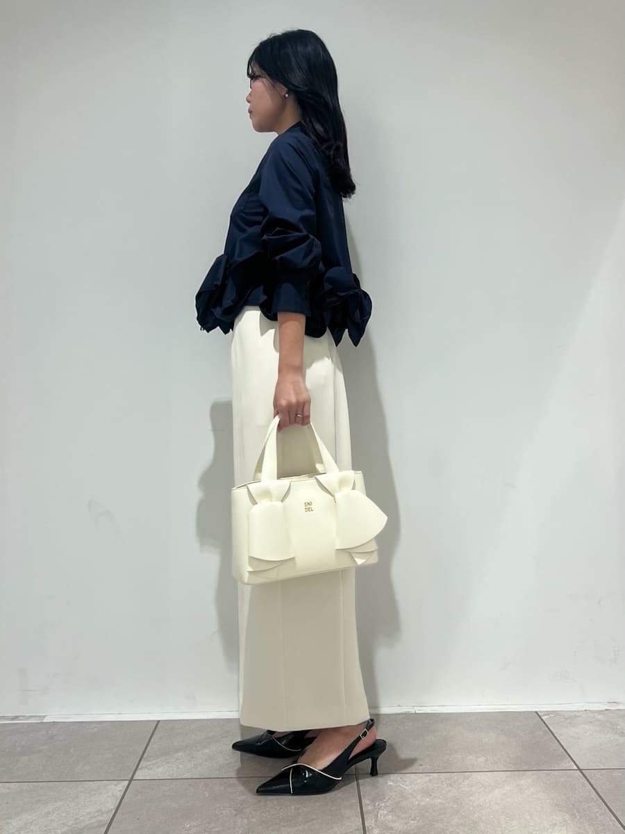 ホワイト系のスカート、ブルー系のシャツ/ブラウス、ブラック系のパンプスを着用したレディースの冬コーディネートの2枚目の写真