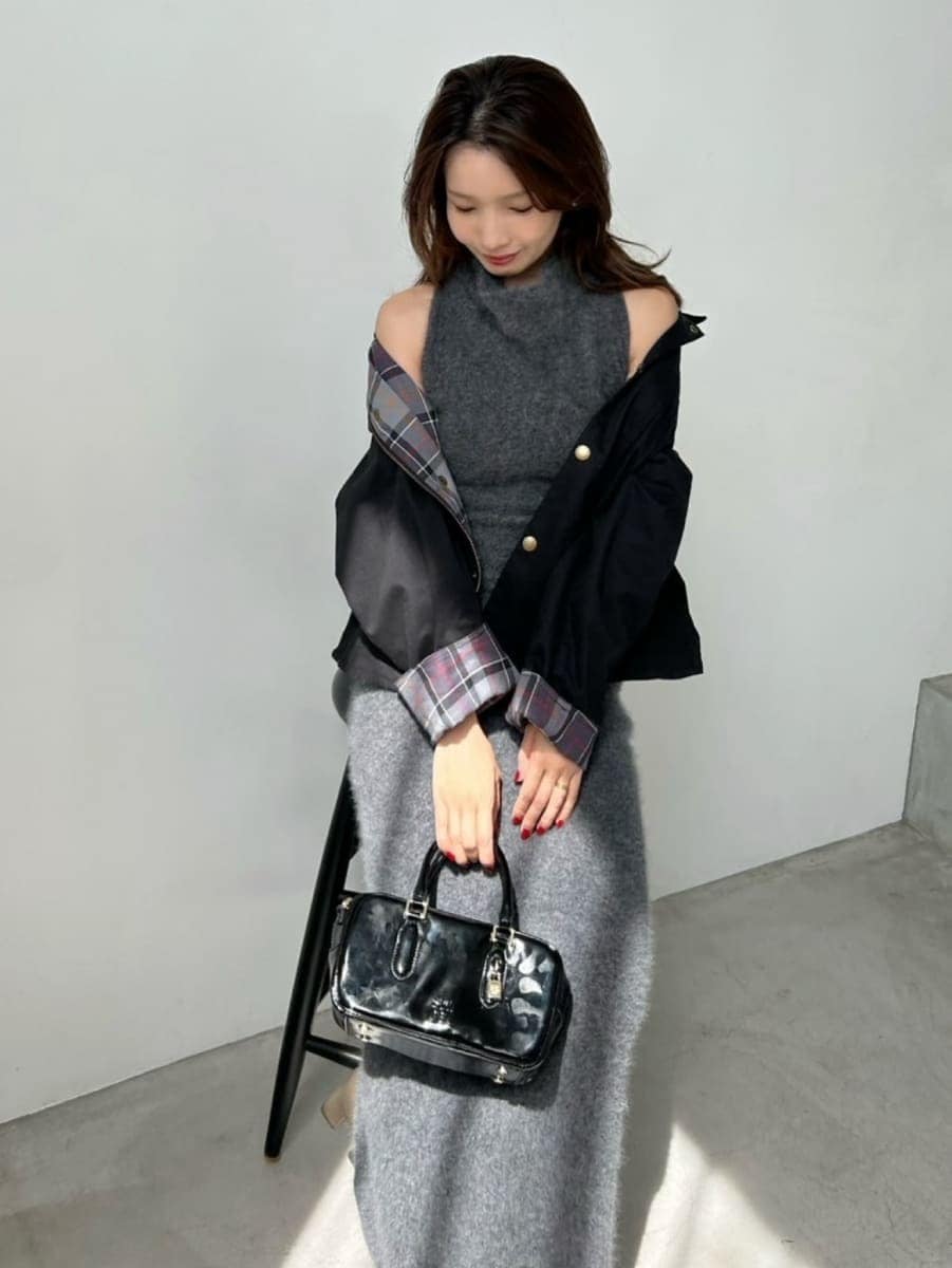 ブラック系のブルゾン、ブラック系のボストンバッグ、グレー系のワンピースを着用したレディースの秋コーディネートの3枚目の写真