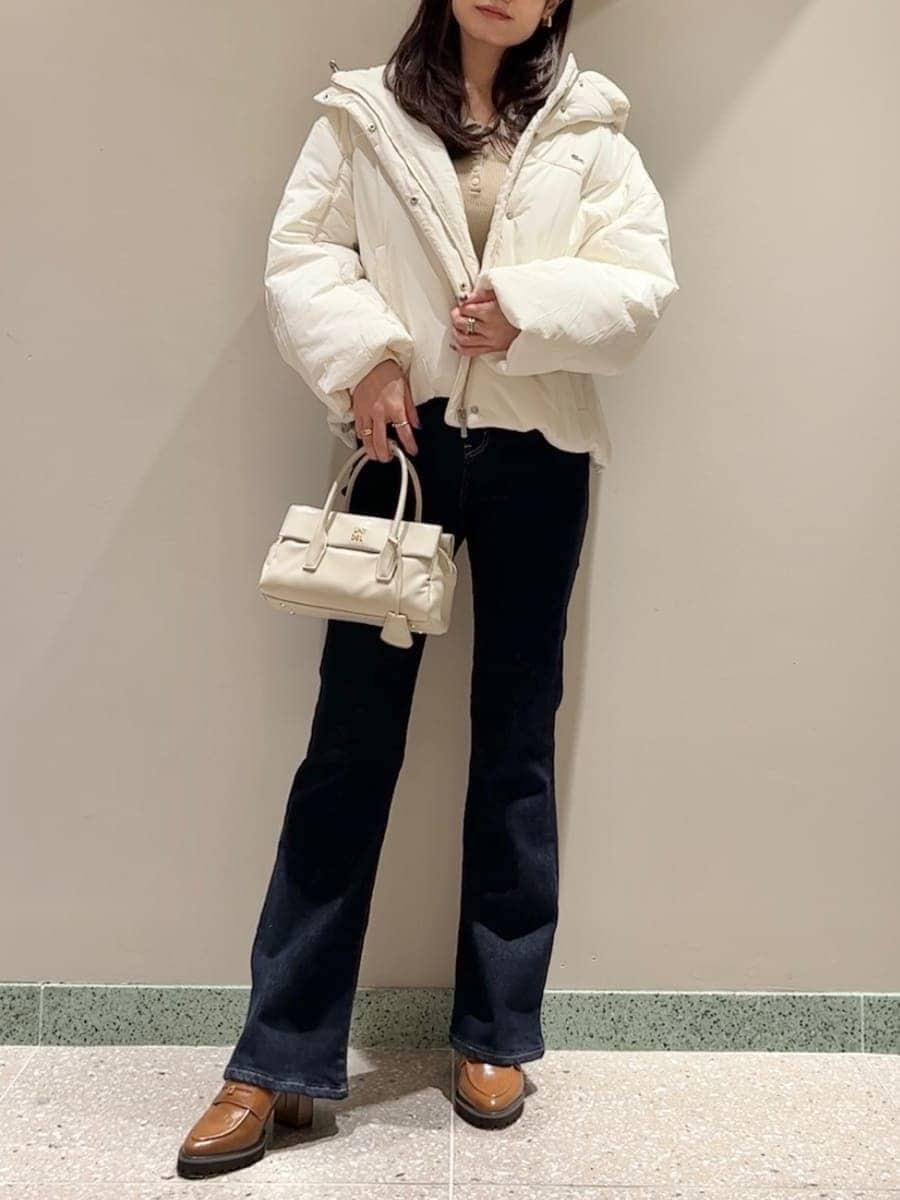 ホワイト系のダウンジャケット/コート、イエロー系のニット/セーター、ブルー系のその他パンツを着用したレディースの秋コーディネートの3枚目の写真