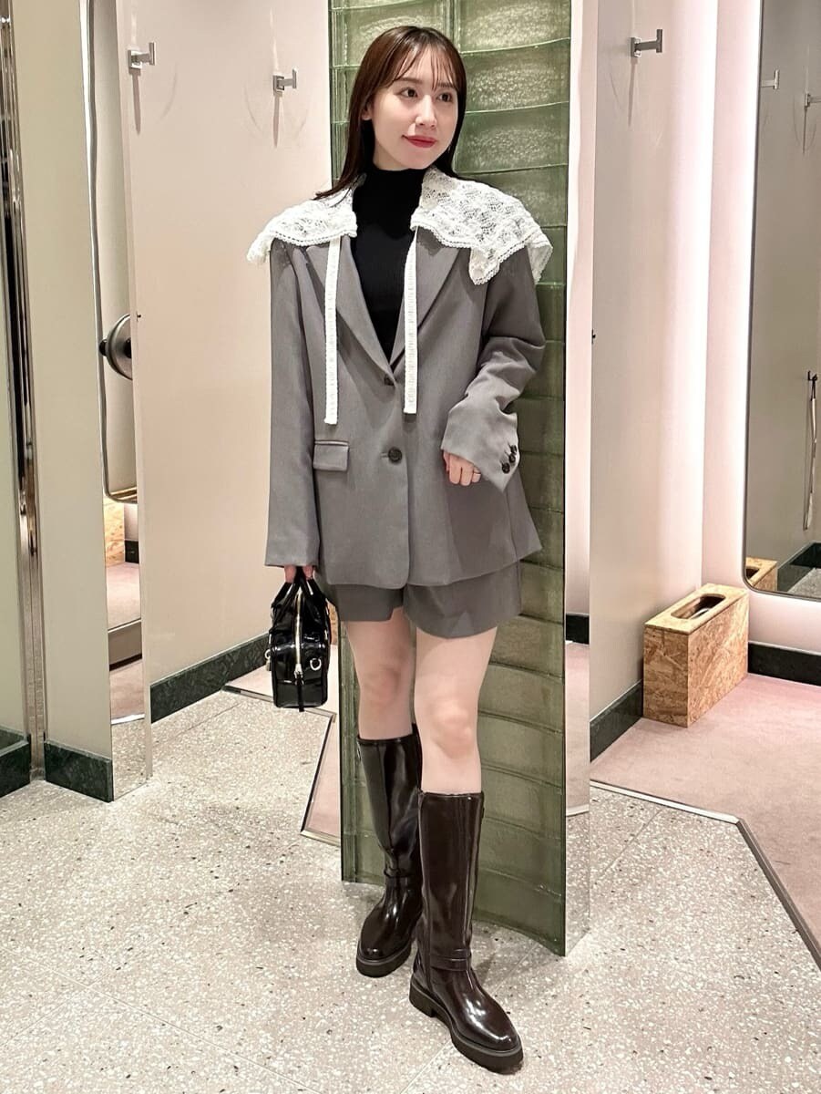 グレー系のテーラードジャケット、グレー系のその他パンツ、ブラウン系のブーツを着用したレディースの秋コーディネートの2枚目の写真