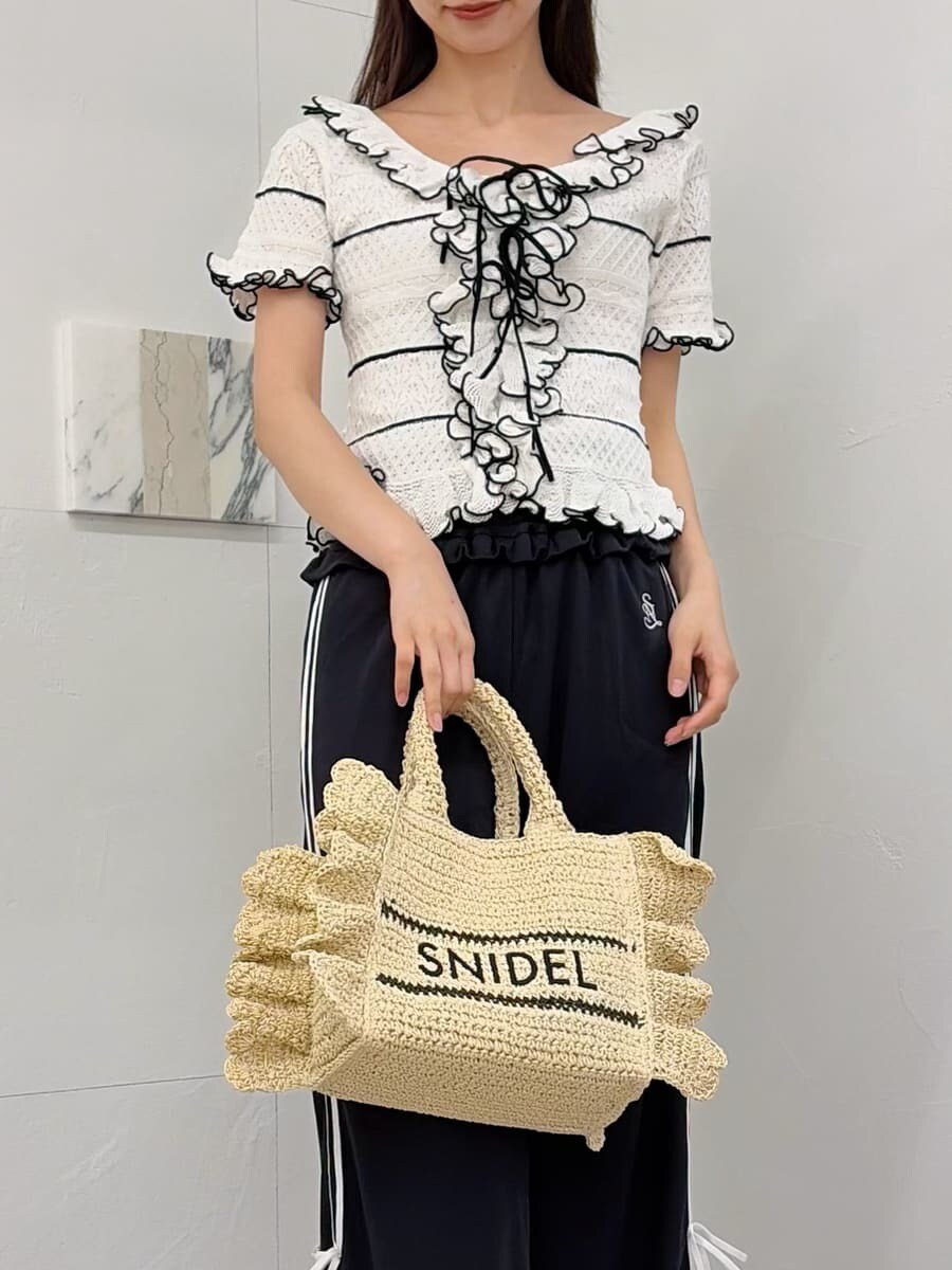 ベージュ系のショルダーバッグ、ブルー系のその他パンツ、ホワイト系のニット/セーターを着用したレディースの春コーディネートの5枚目の写真