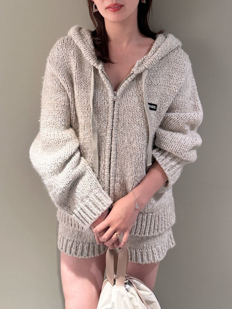 ホワイト系のその他パンツ、ホワイト系のニット/セーター、ベージュ系のハンドバッグを着用したレディースの夏コーディネートの6枚目の写真