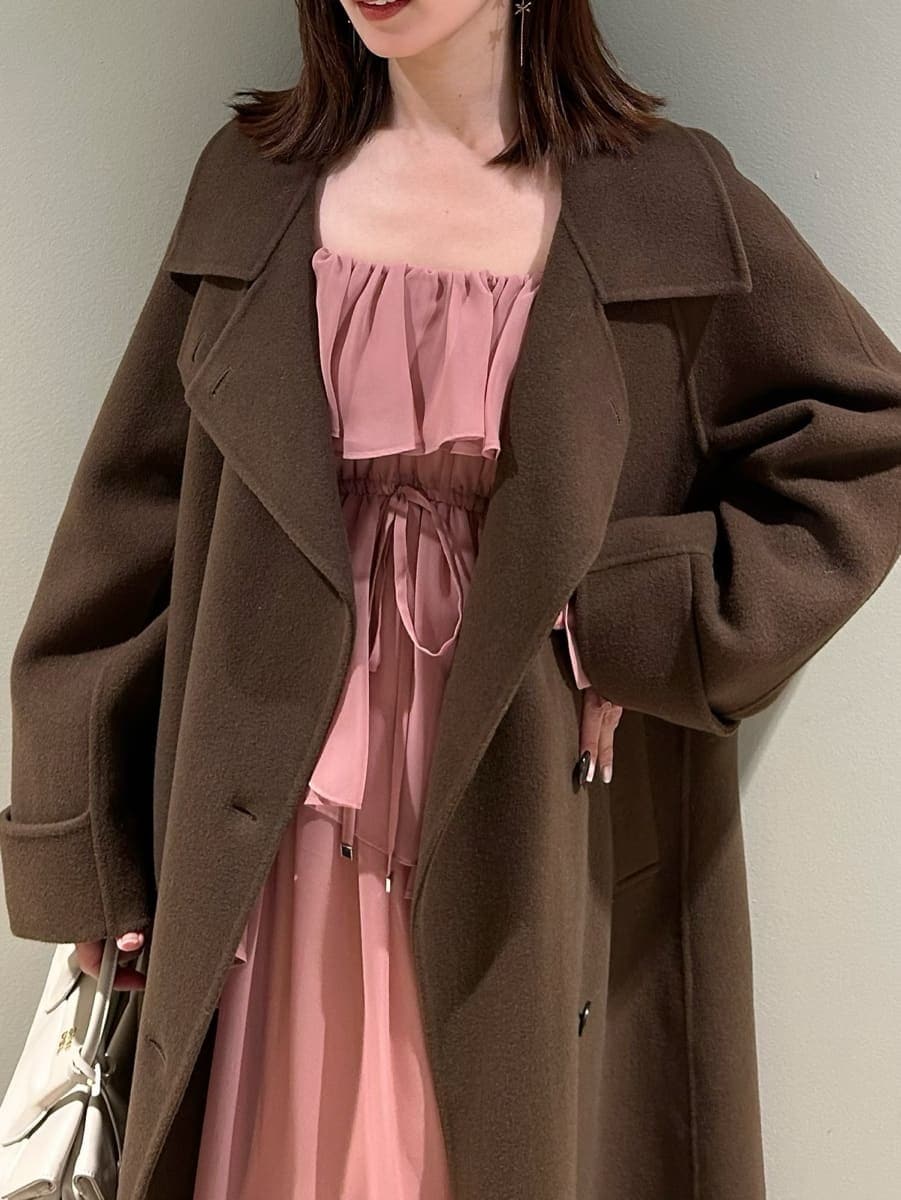 ブラウン系のブーツ、オレンジ系のワンピース、ホワイト系のボストンバッグを着用したレディースの冬コーディネートの3枚目の写真