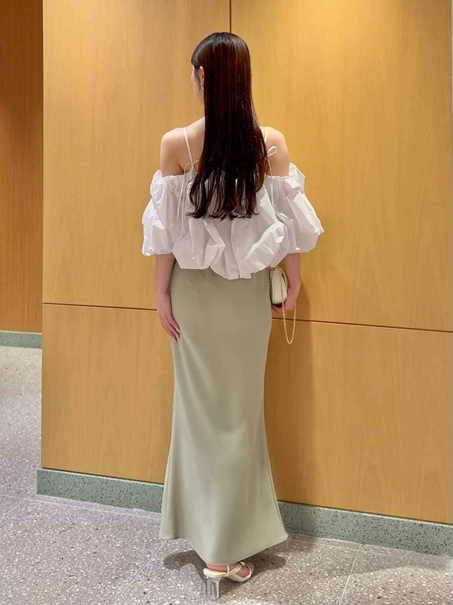 グリーン系のスカート、ホワイト系のシャツ/ブラウス、ホワイト系のショルダーバッグを着用したレディースの春コーディネートの3枚目の写真