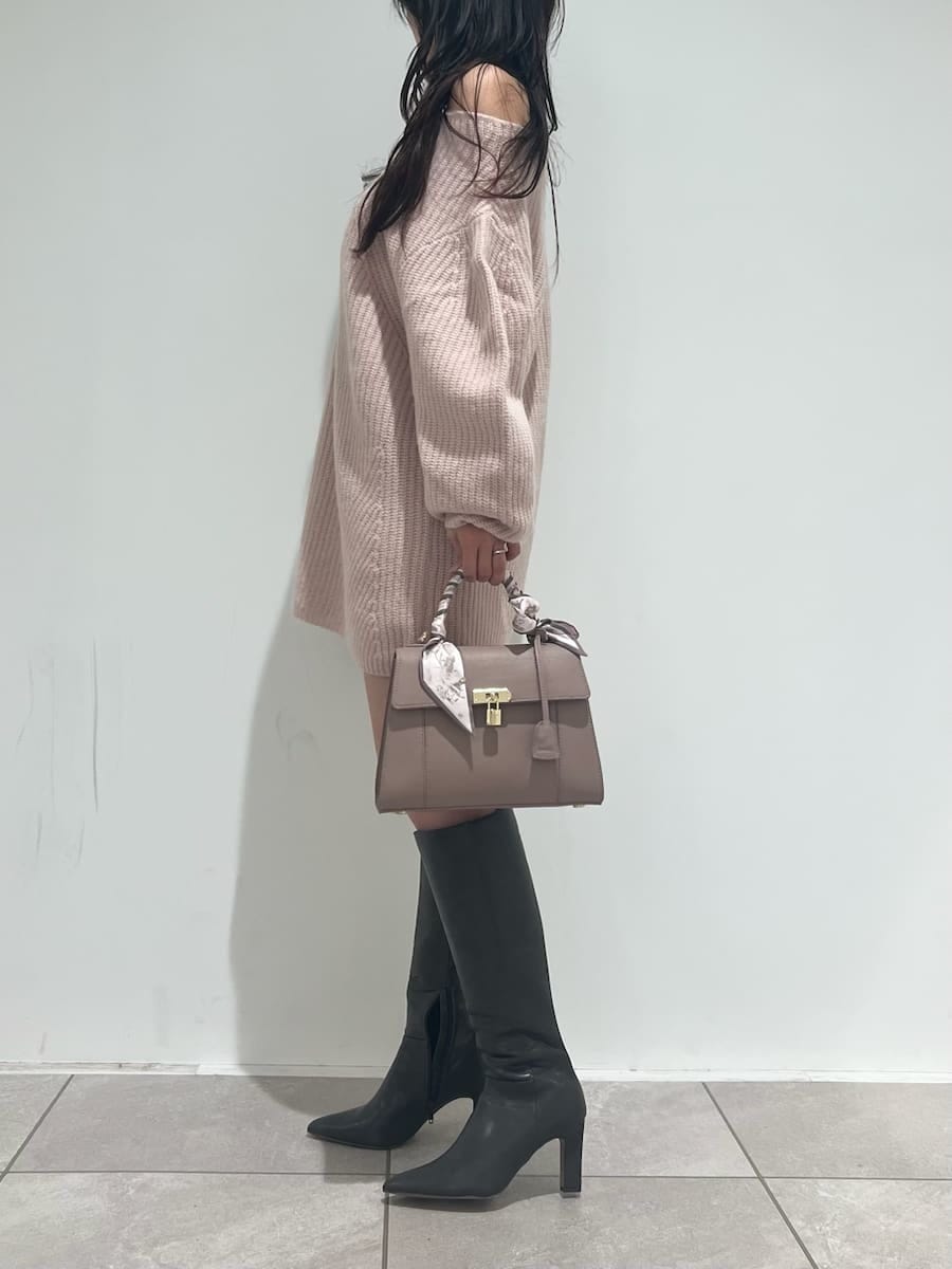 グレー系のブーツ、ピンク系のハンドバッグ、ピンク系のワンピースを着用したレディースの秋コーディネートの2枚目の写真