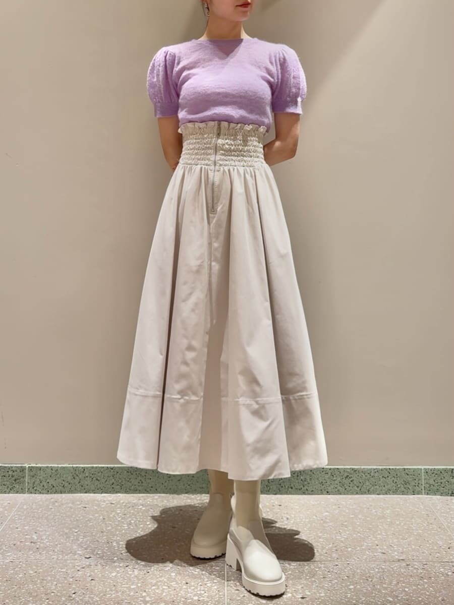 パープル系のニット/セーター、ホワイト系のスカート、ベージュ系のショルダーバッグを着用したレディースの夏コーディネートの5枚目の写真