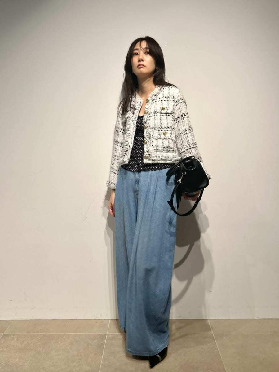 ホワイト系のノーカラージャケット、ブラック系のキャミソール、ブラック系のパンプスを着用したレディースの春コーディネートの2枚目の写真