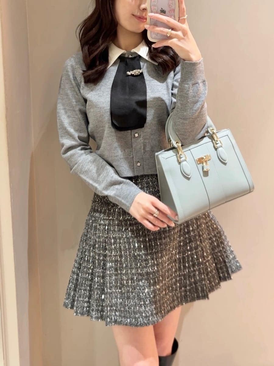 ブラック系のブーツ、グレー系のスカート、ブルー系のハンドバッグを着用したレディースの冬コーディネートの5枚目の写真