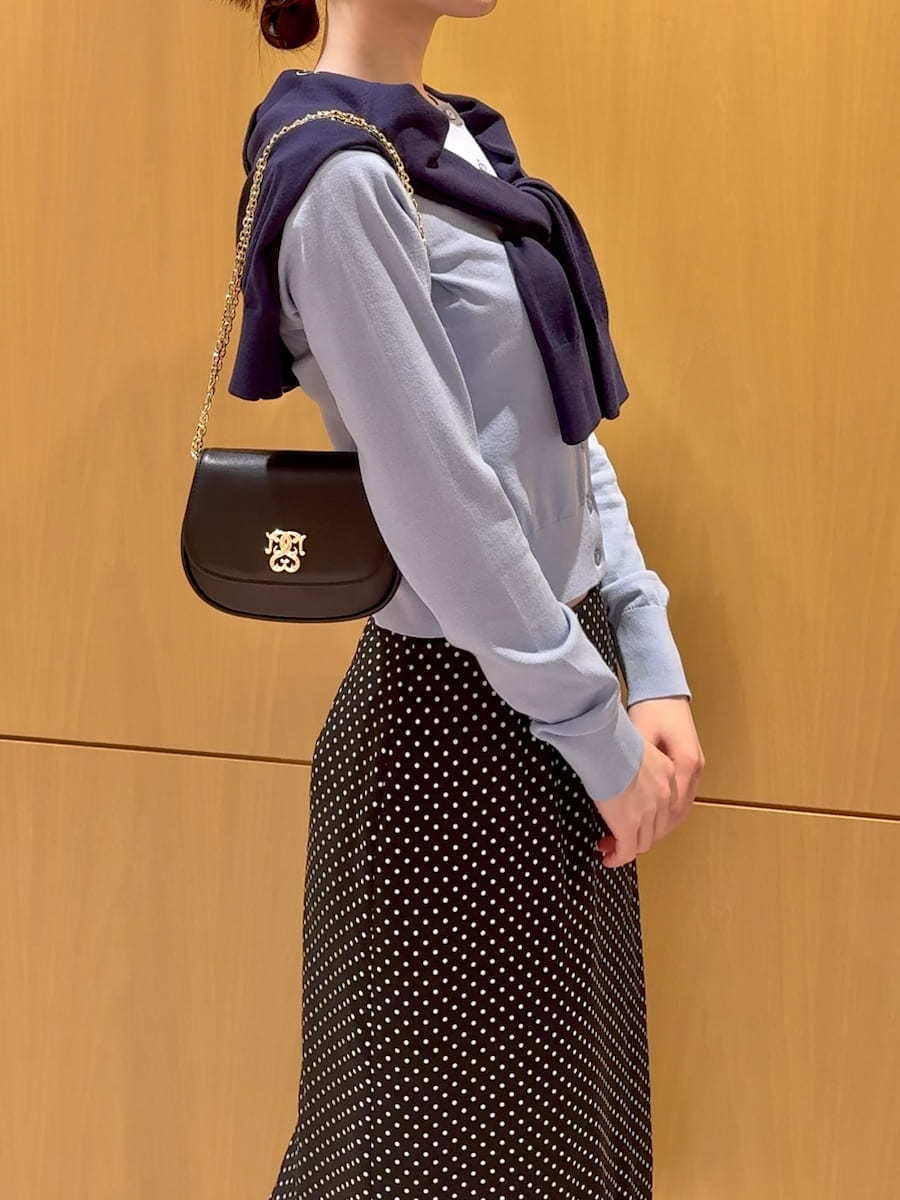 ブラック系のスカート、ブルー系のカーディガン/ボレロ、ブラック系のショルダーバッグを着用したレディースの冬コーディネートの5枚目の写真