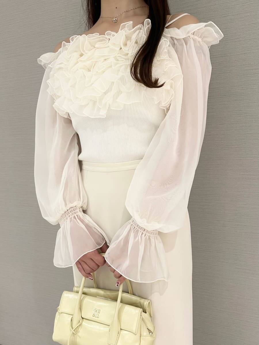 ホワイト系のスカート、ホワイト系のニット/セーター、イエロー系のボストンバッグを着用したレディースの冬コーディネートの4枚目の写真