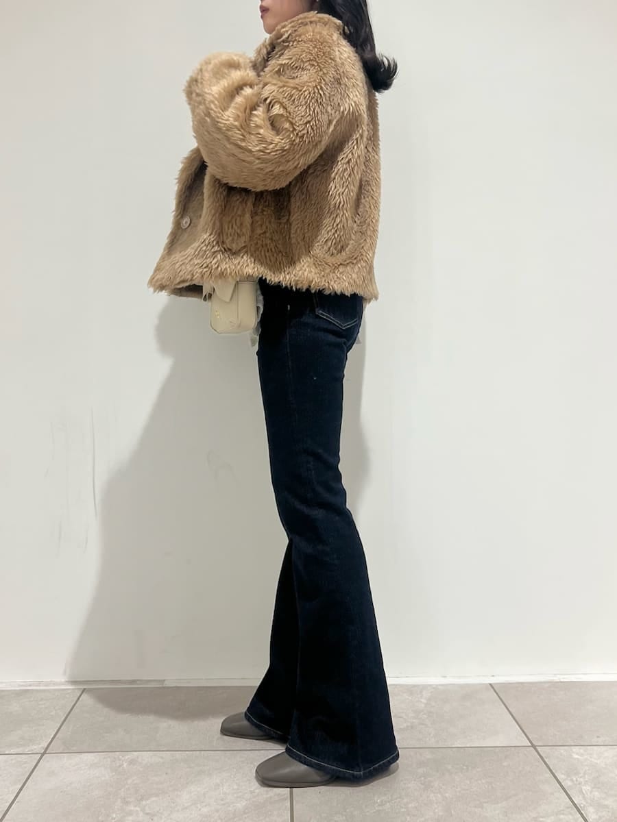 ブルー系のその他パンツ、ホワイト系のニット/セーター、ホワイト系のショルダーバッグを着用したレディースの冬コーディネートの2枚目の写真