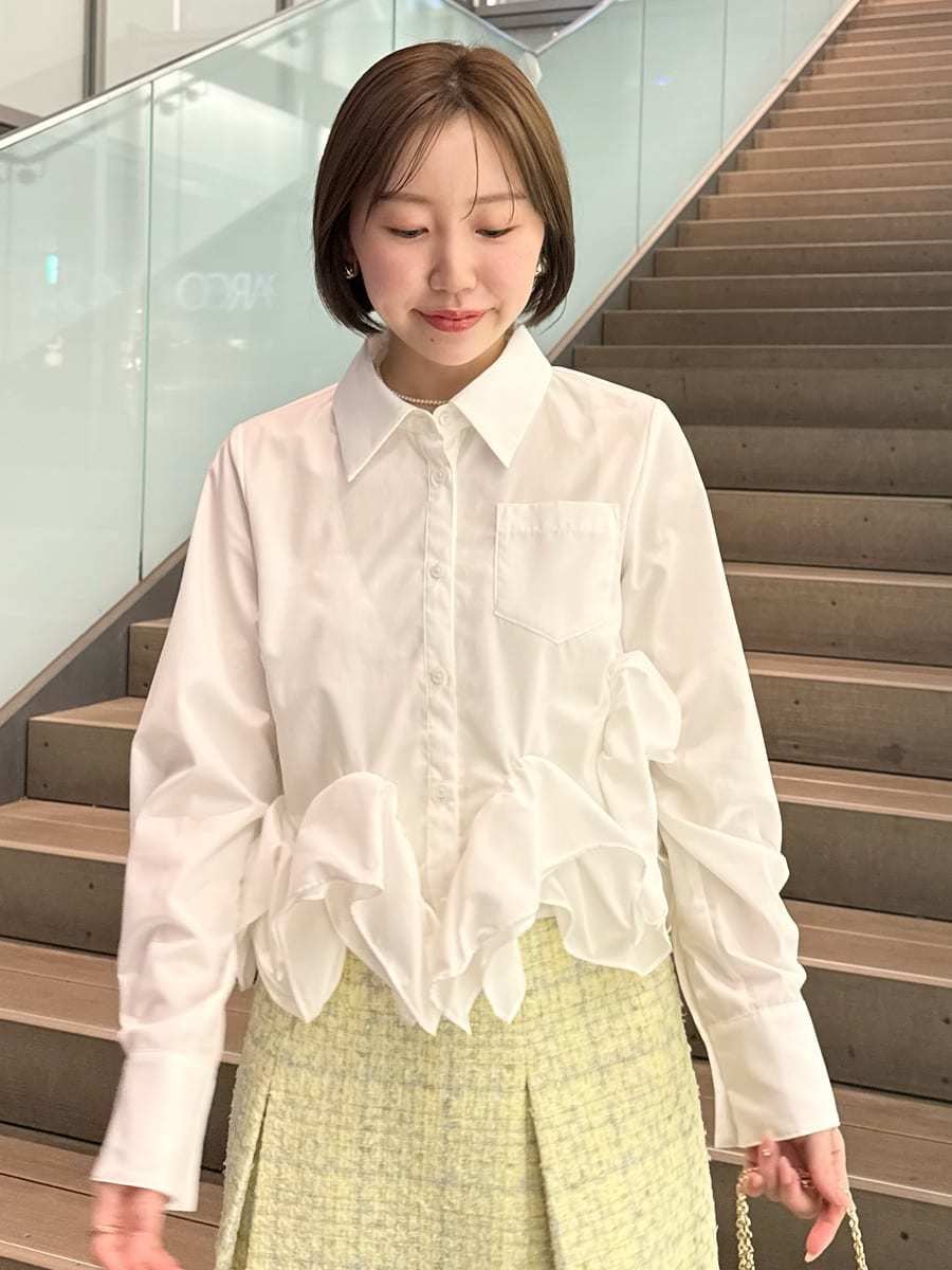 イエロー系のスカート、ホワイト系のシャツ/ブラウス、イエロー系のショルダーバッグを着用したレディースの冬コーディネートの3枚目の写真