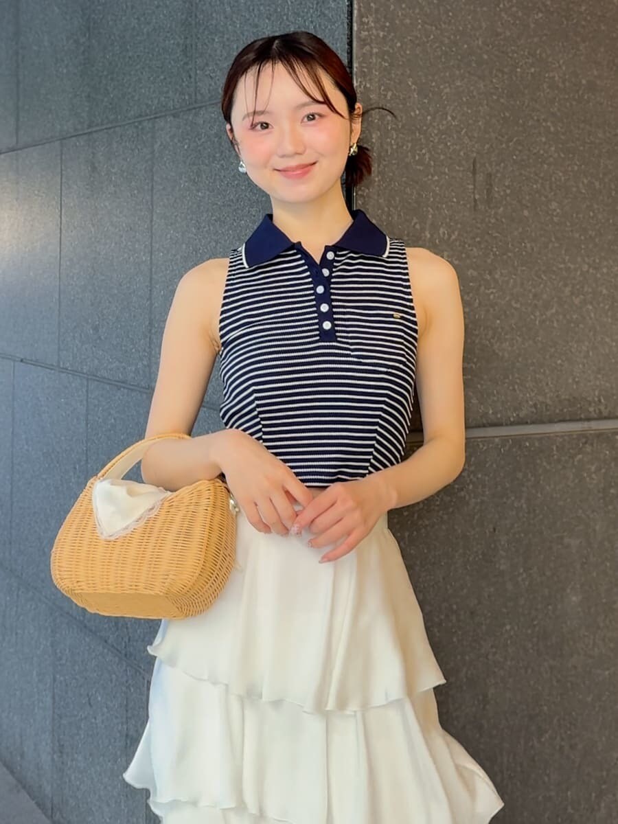 ホワイト系のかごバッグ、ホワイト系のスカート、ホワイト系のサンダルを着用したレディースの夏コーディネートの4枚目の写真