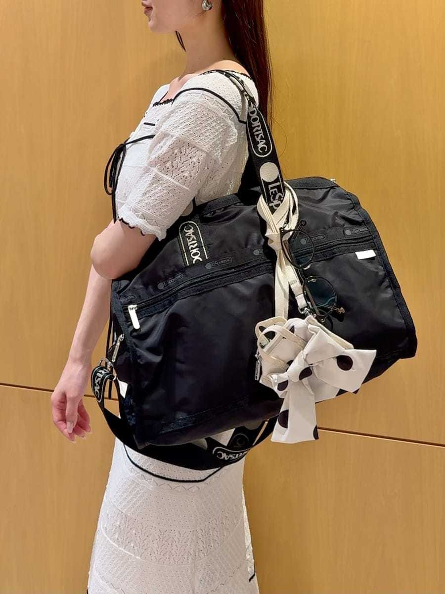 ホワイト系のワンピース、ブラック系のショルダーバッグ、その他のサンダルを着用したレディースの春コーディネートの6枚目の写真