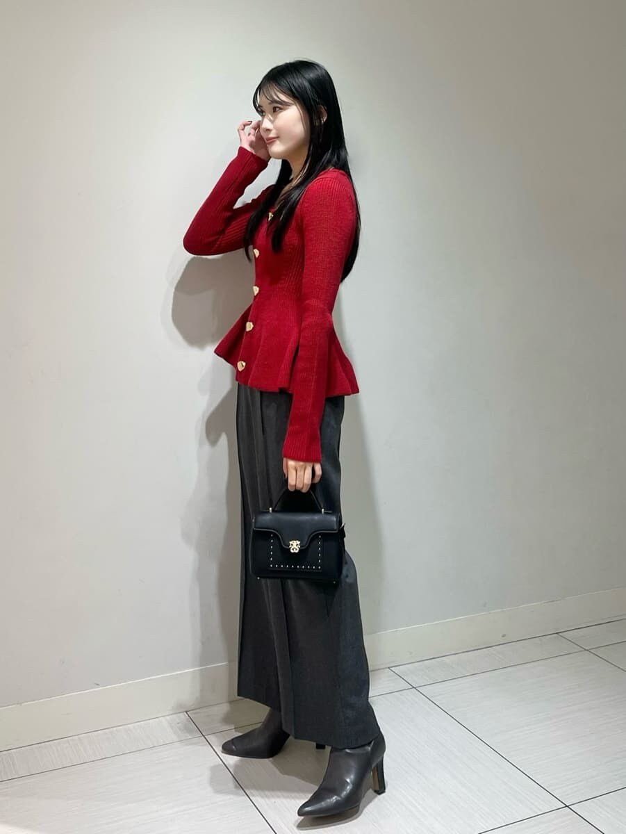 レッド系のニット/セーター、グレー系のその他パンツ、ブラック系のショルダーバッグを着用したレディースの秋コーディネートの2枚目の写真