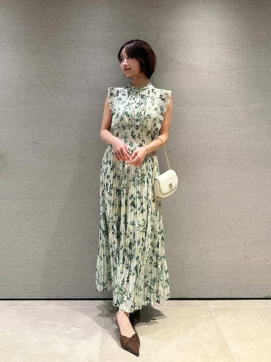 グリーン系のワンピース、ホワイト系のカーディガン/ボレロ、ブラウン系のパンプスを着用したレディースの冬コーディネートの6枚目の写真