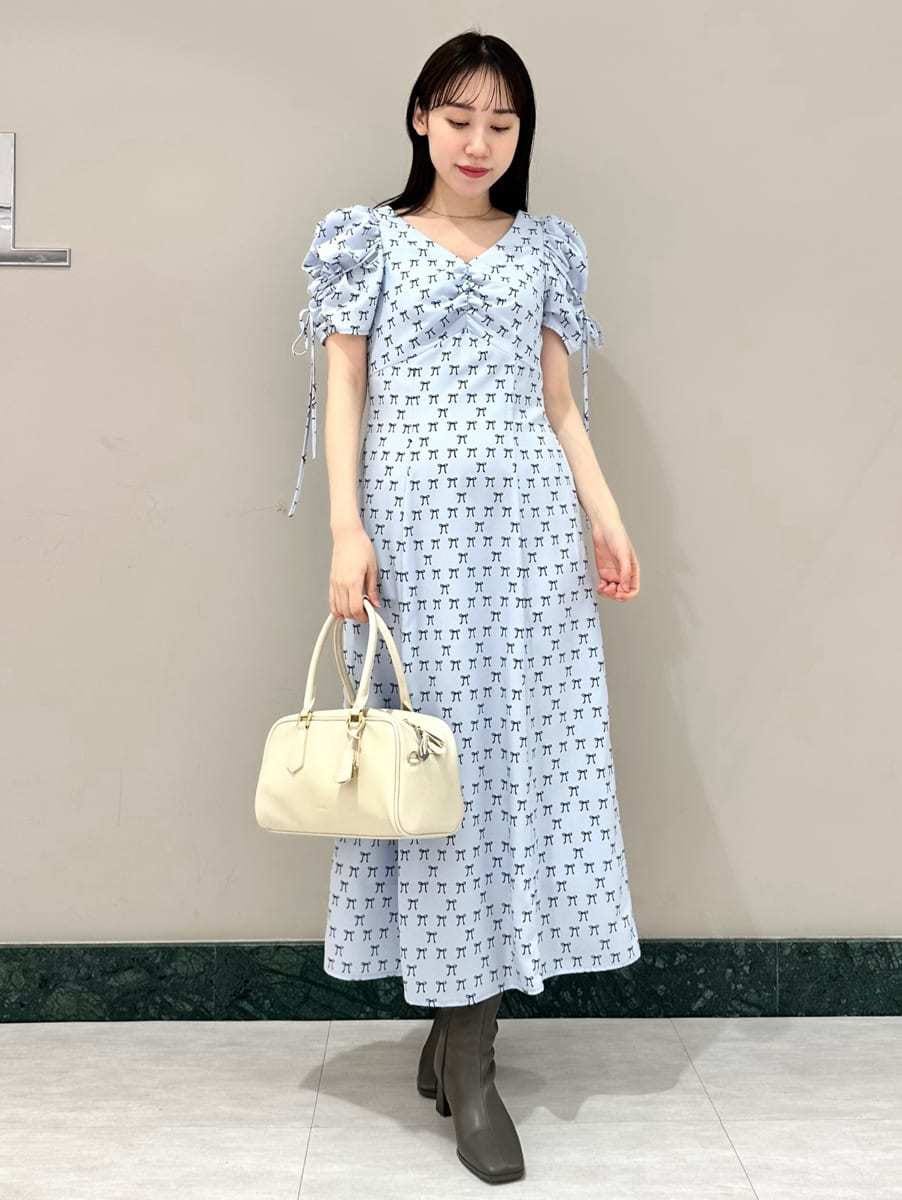 ブルー系のワンピース、ホワイト系のカーディガン/ボレロ、ホワイト系のボストンバッグを着用したレディースの冬コーディネートの2枚目の写真