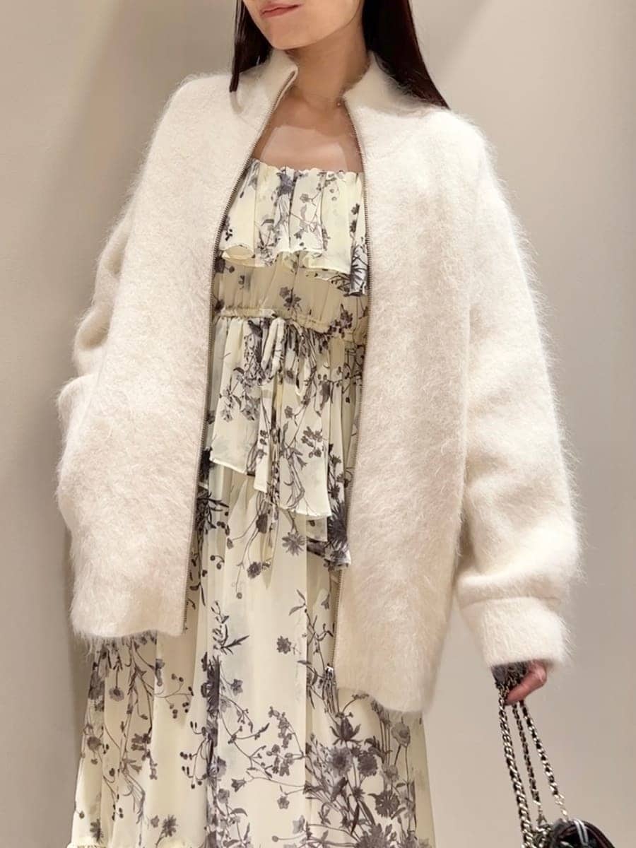 ホワイト系のブルゾン、イエロー系のワンピース、ブラック系のブーツを着用したレディースの秋コーディネートの4枚目の写真