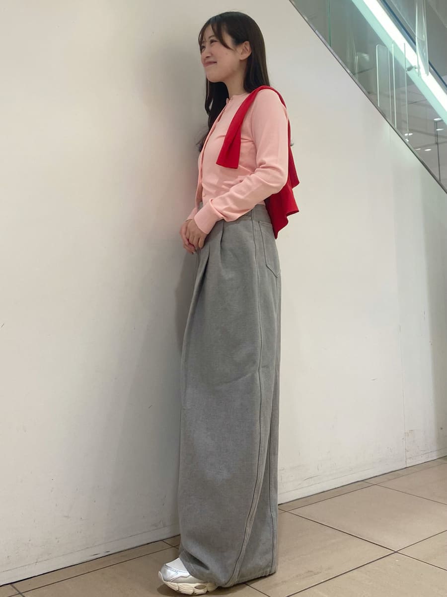 グレー系のデニムパンツ、レッド系のカーディガン/ボレロ、シルバー系のスニーカーを着用したレディースの冬コーディネートの2枚目の写真