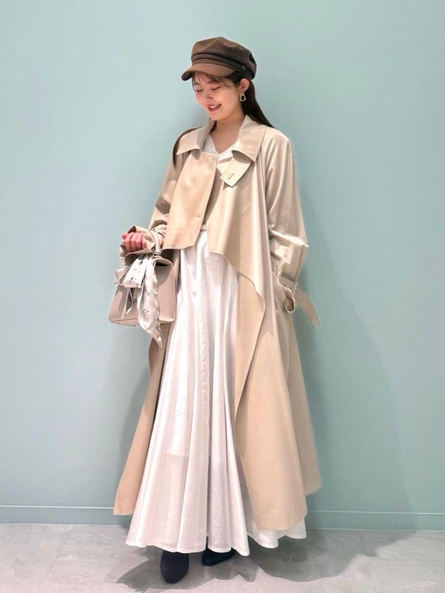 レッド系のブーツ、ベージュ系のトレンチコート、ベージュ系のハンドバッグを着用したレディースの冬コーディネートの6枚目の写真