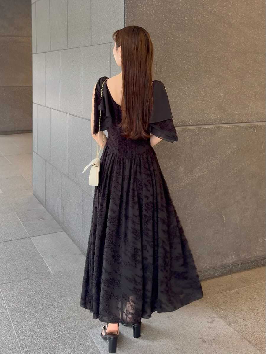 ブラック系のワンピース、ホワイト系のショルダーバッグ、ホワイト系の折りたたみ傘を着用したレディースの春コーディネートの4枚目の写真