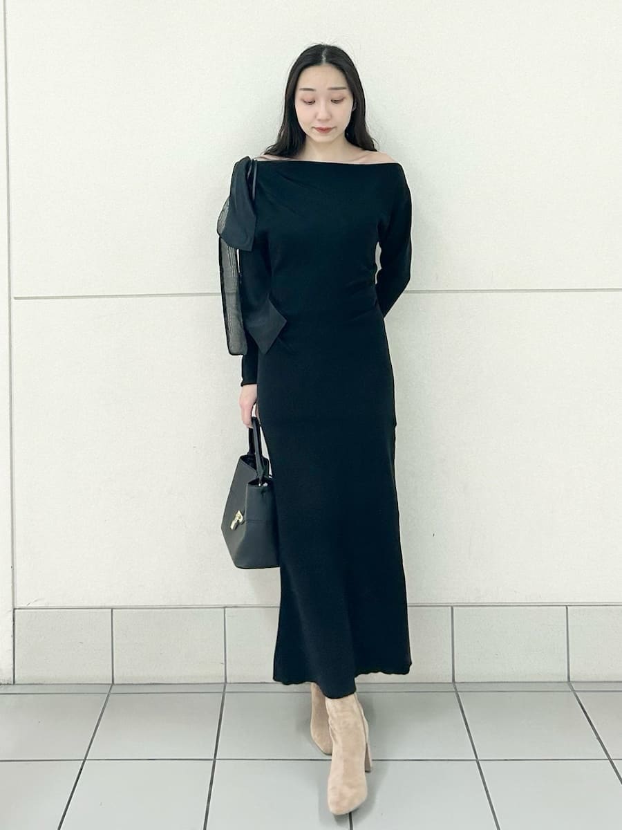 ベージュ系のブーツ、ブラック系のハンドバッグ、ブラック系のワンピースを着用したレディースの冬コーディネートの2枚目の写真