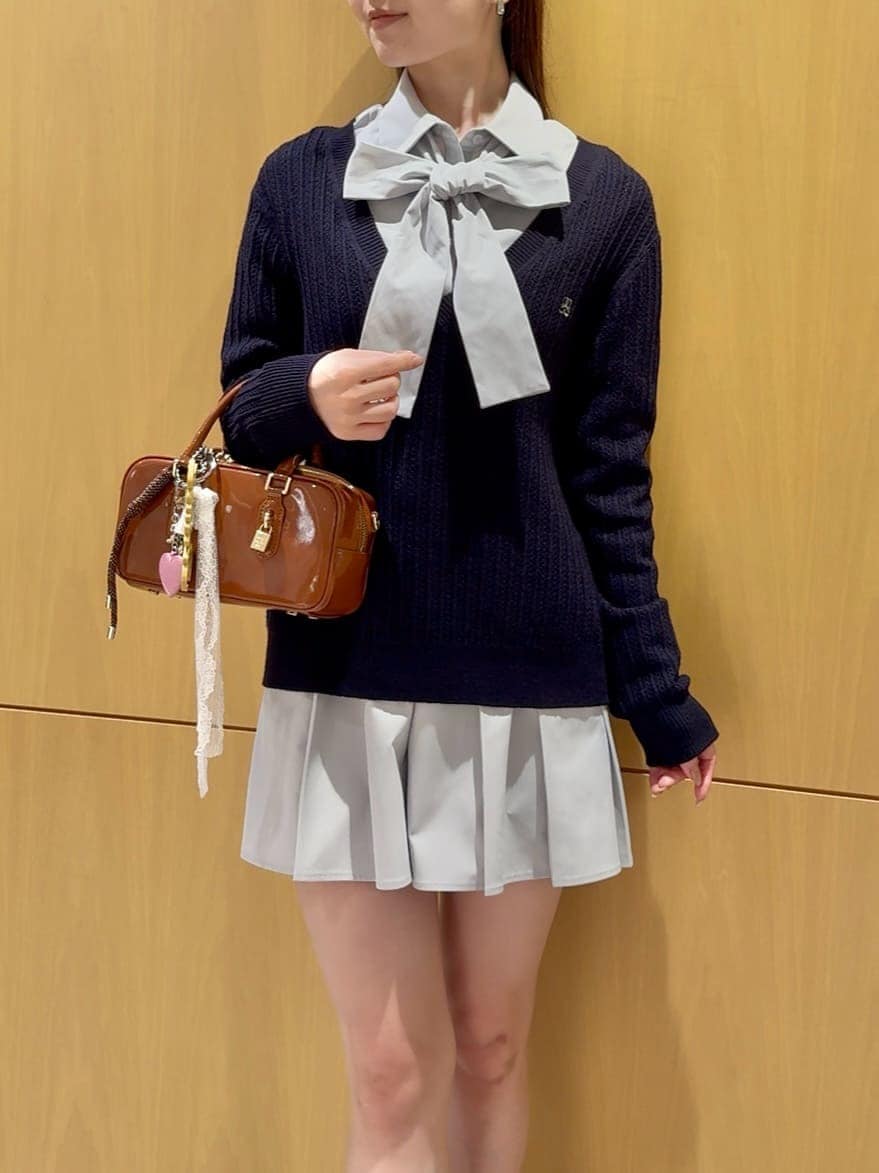 ベージュ系のステンカラーコート、ブルー系のその他トップス、ブラウン系のボストンバッグを着用したレディースの秋コーディネートの7枚目の写真