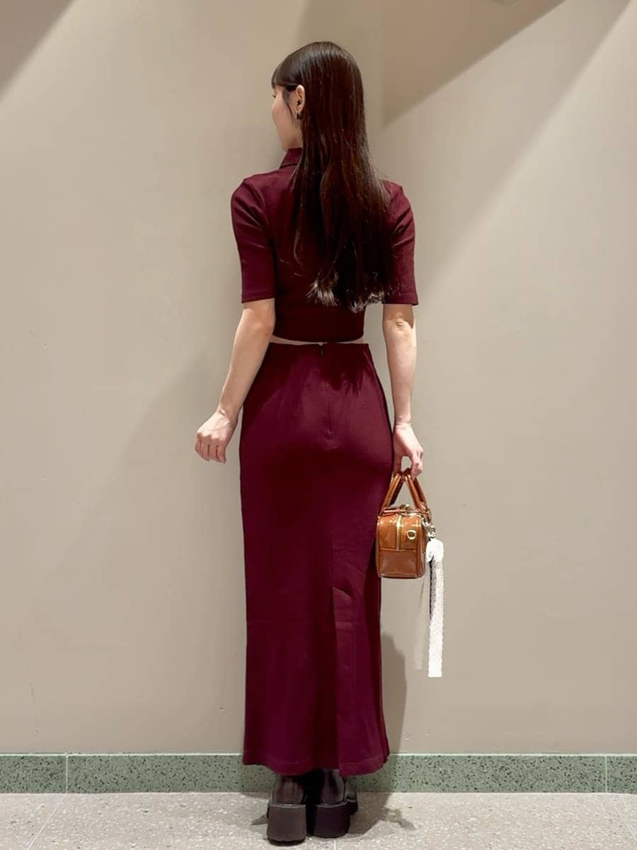 ブラウン系のワンピース、ブラウン系のボストンバッグ、ホワイト系のチャームを着用したレディースの秋コーディネートの3枚目の写真