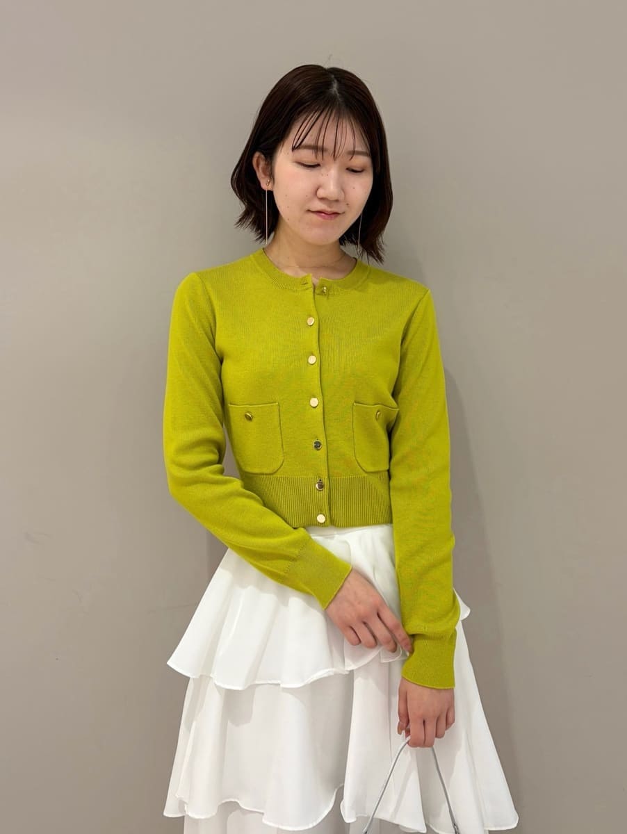 イエロー系のワンピース、ゴールド系のイヤリングを着用したレディースの冬コーディネートの5枚目の写真