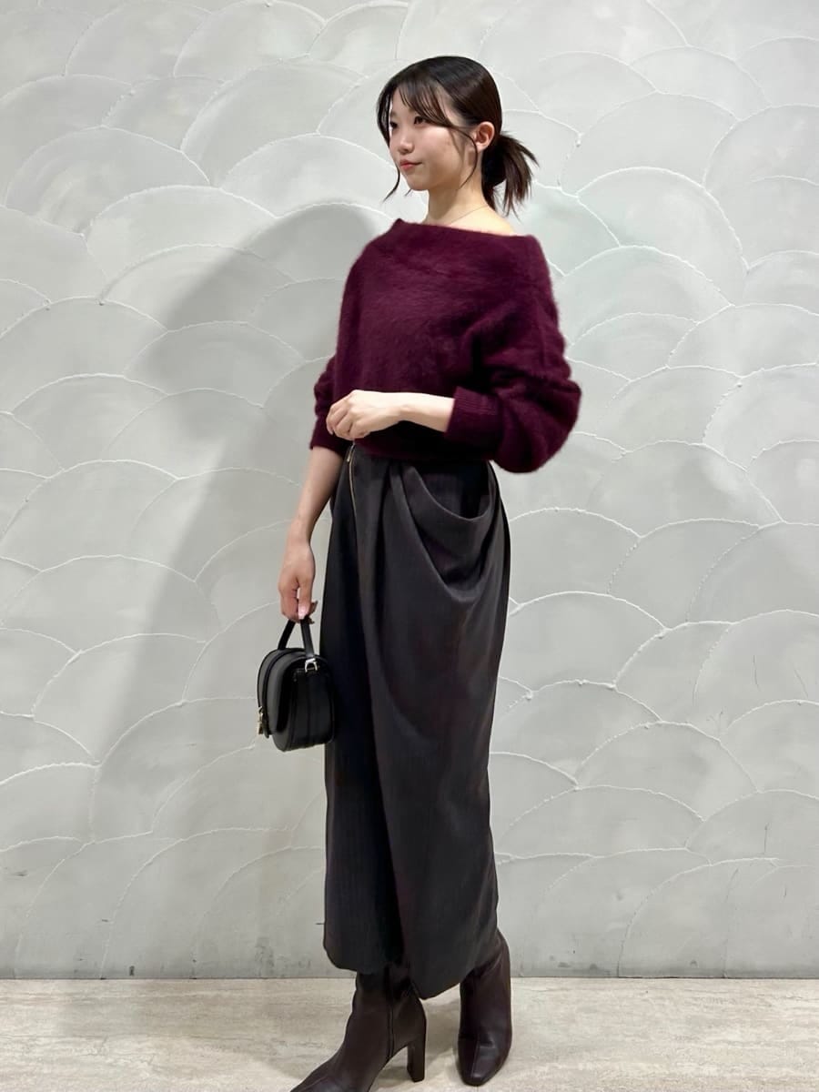 レッド系のニット/セーター、グレー系のスカート、ブラック系のハンドバッグを着用したレディースの秋コーディネートの2枚目の写真