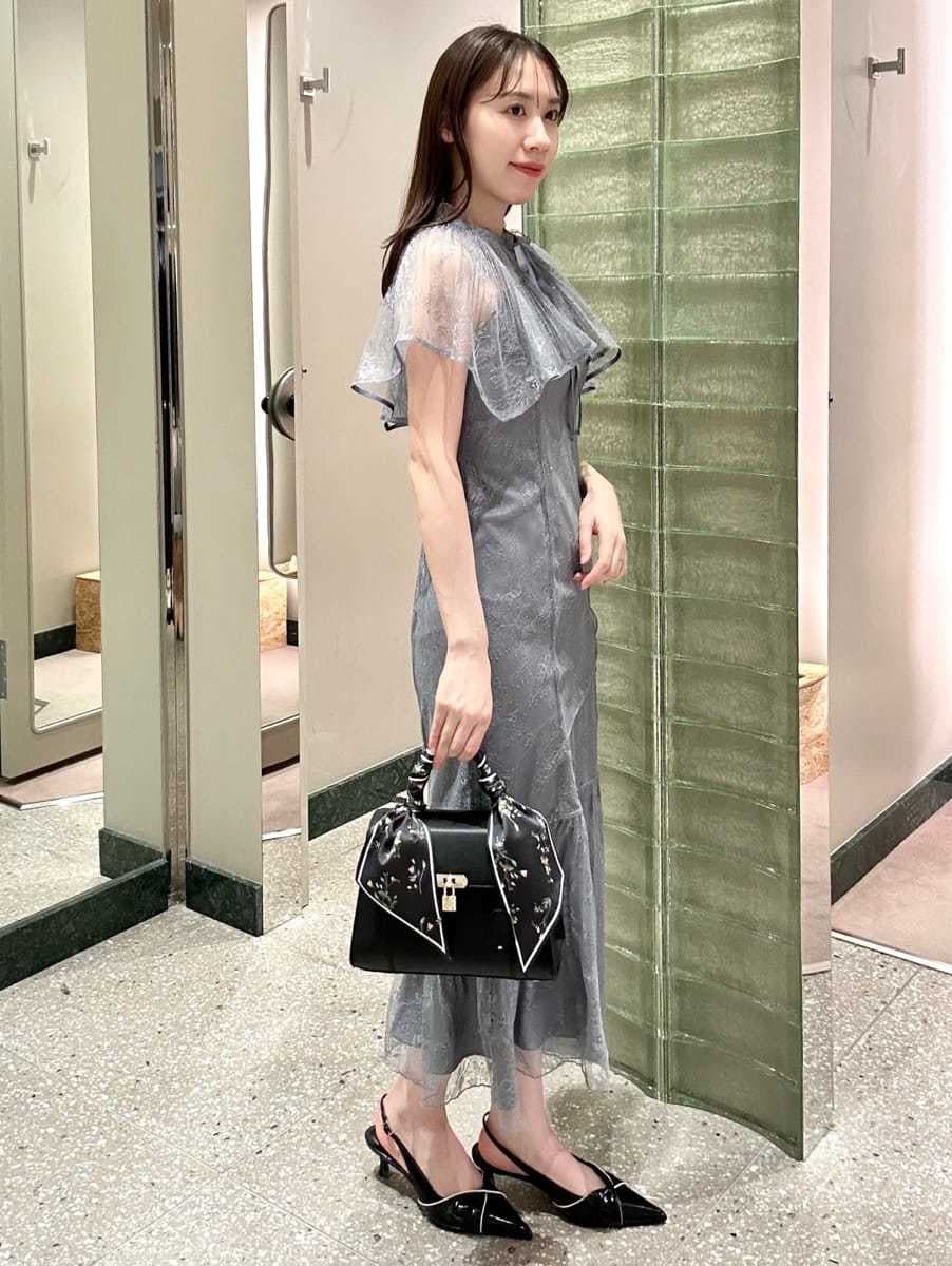 グレー系のドレス、ブラック系のパンプス、ブラック系のハンドバッグを着用したレディースの冬コーディネートの3枚目の写真