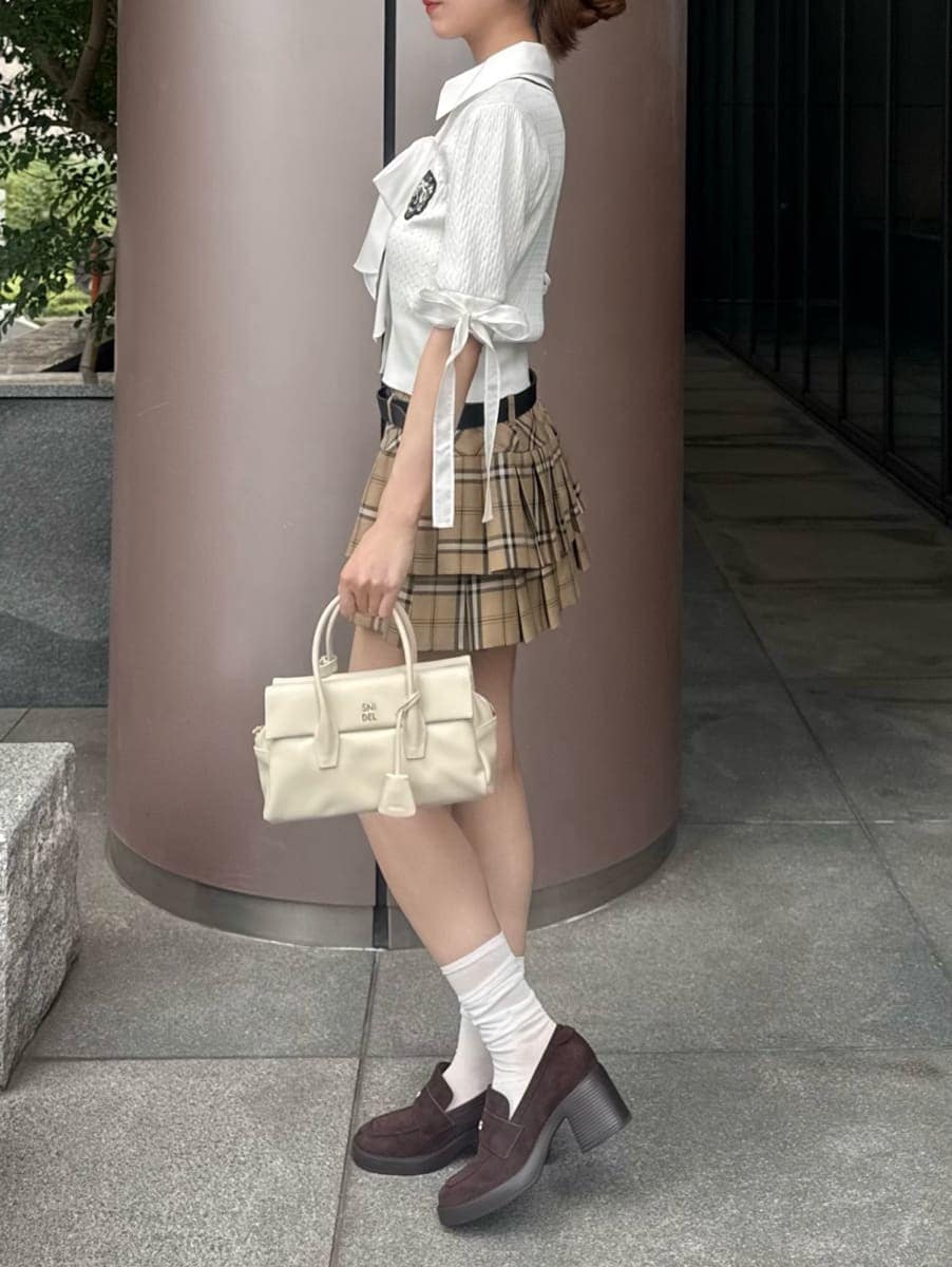 ホワイト系のボストンバッグ、ベージュ系のその他パンツ、ホワイト系のニット/セーターを着用したレディースの夏コーディネートの2枚目の写真