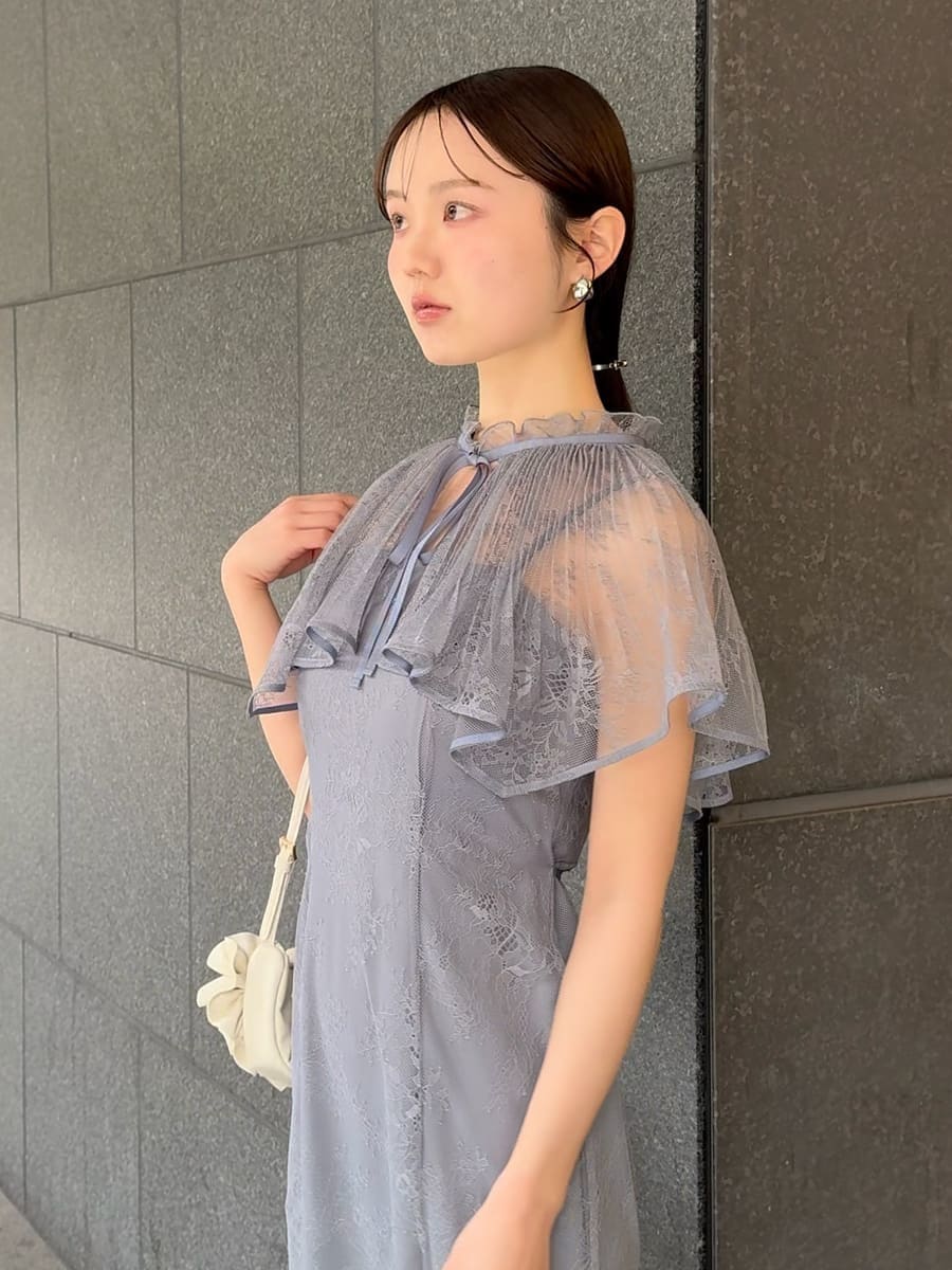 グレー系のドレス、ブラック系のパンプス、ホワイト系のハンドバッグを着用したレディースの春コーディネートの5枚目の写真