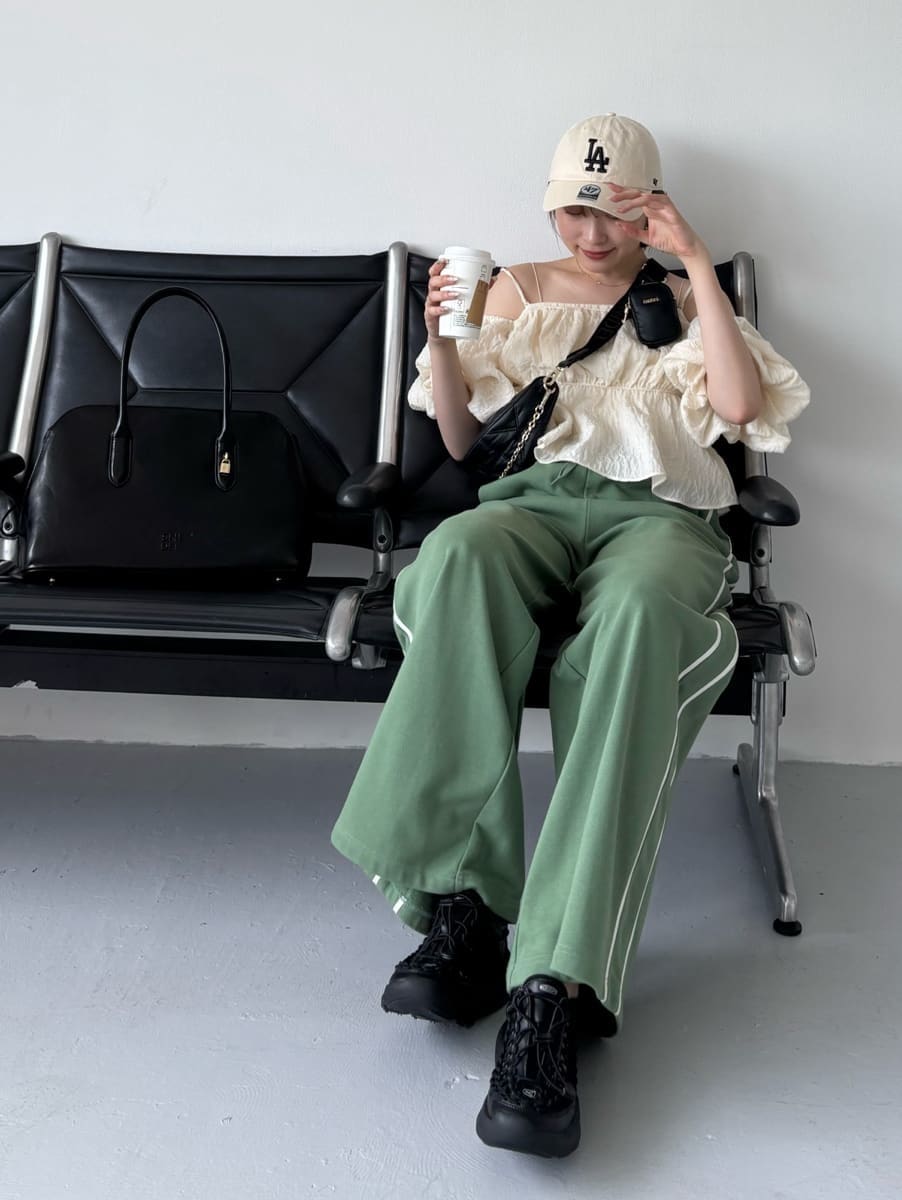 グリーン系のスウェットパンツ、ブラック系のショルダーバッグ、ブラック系のサンダルを着用したレディースの夏コーディネートの2枚目の写真